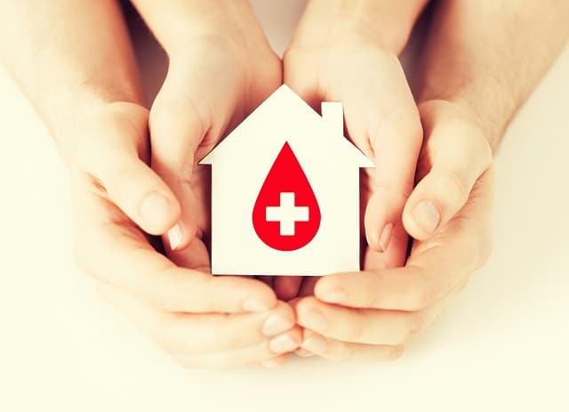 hands holding house with donor sign