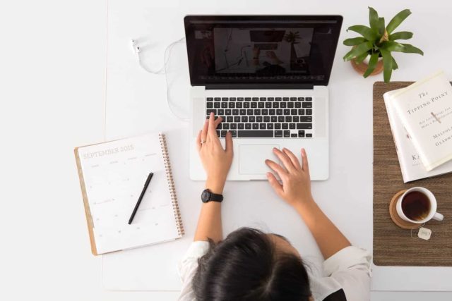 woman at a desk proofreading online