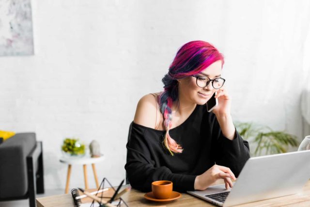 18 year old with pink hair talking on a phone