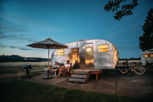 man and woman sitting in front of RV