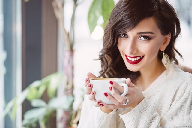 Woman holding coffee cup smiling