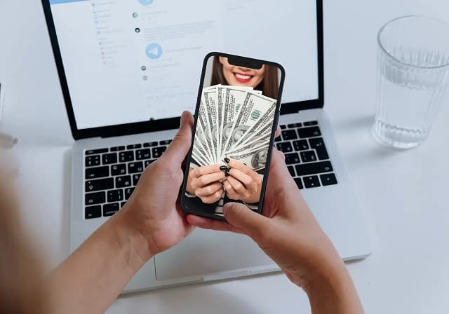 person looking at smartphone image of woman holding money