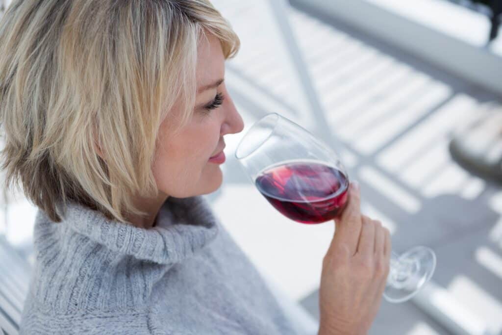 blonde woman smelling a glass of wine