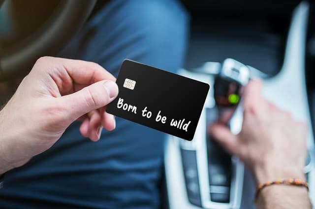 Man holding Cash Card that says born to be wild
