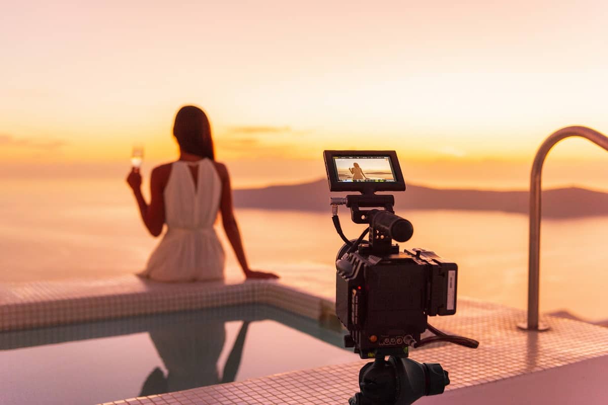 Actress being filmed sitting by a pool