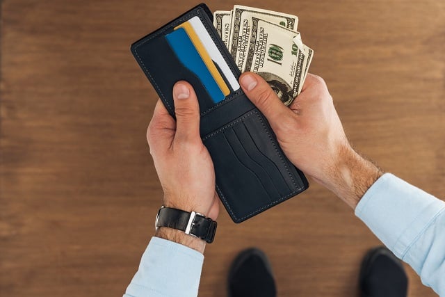 Man holding wallet with Visa gift cards and cash