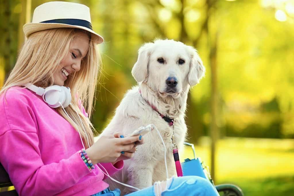 woman sitting in park with dog