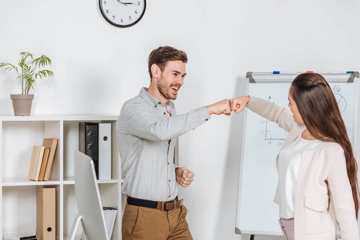 Life coach and client fist bumping after successful session