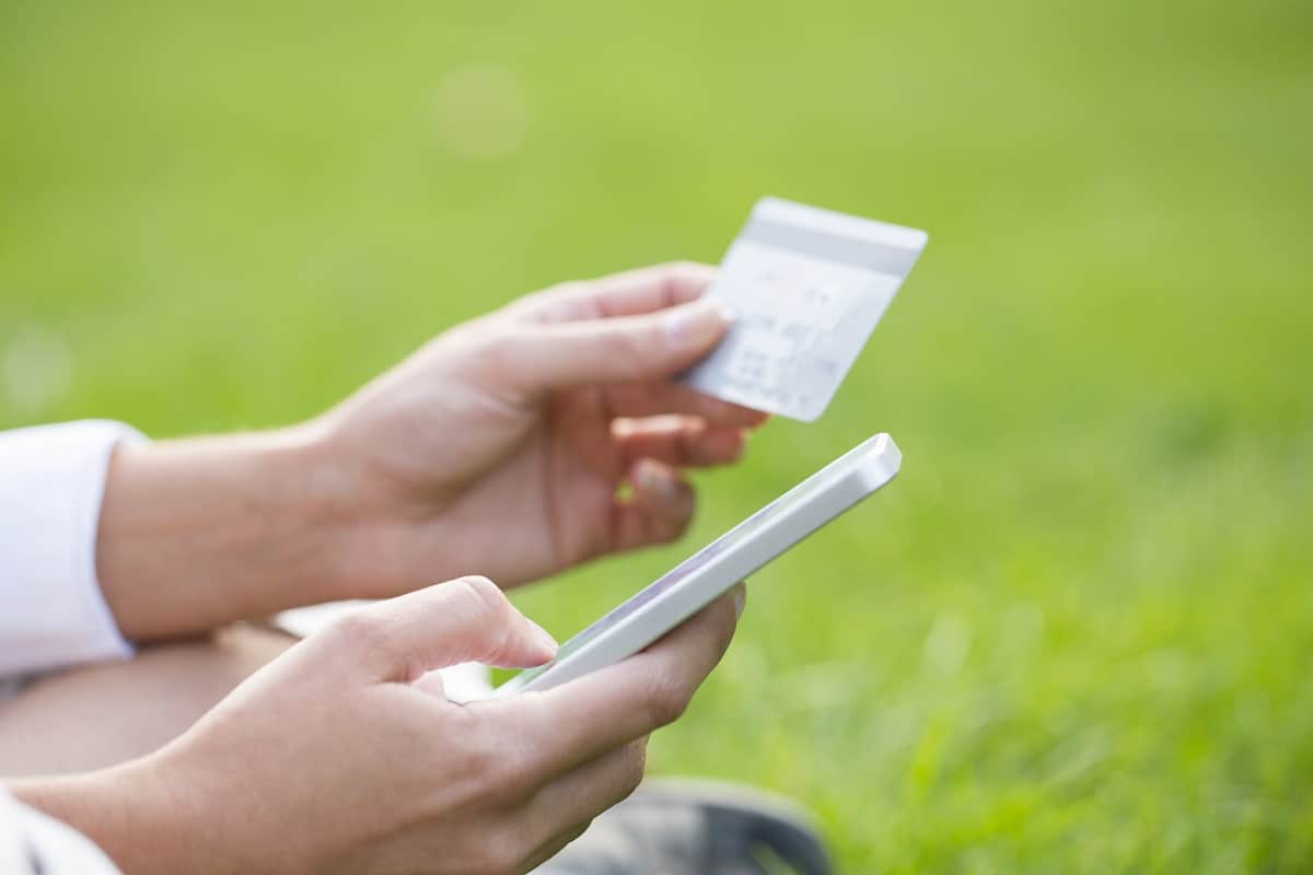 Person holding iTunes gift card and smartphone