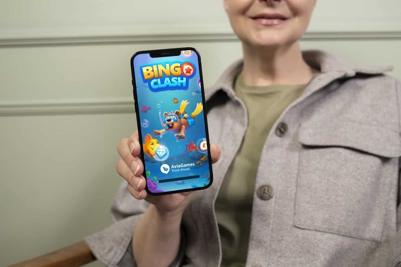 Woman holding a smartphone displaying Bingo Clash
