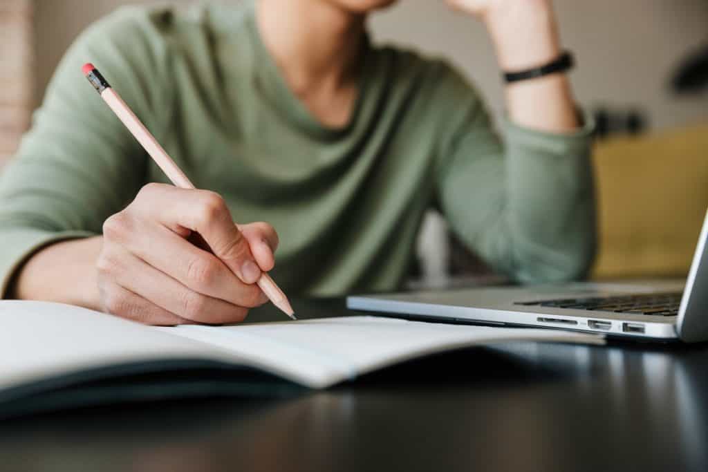 Person taking notes during online proofreading course