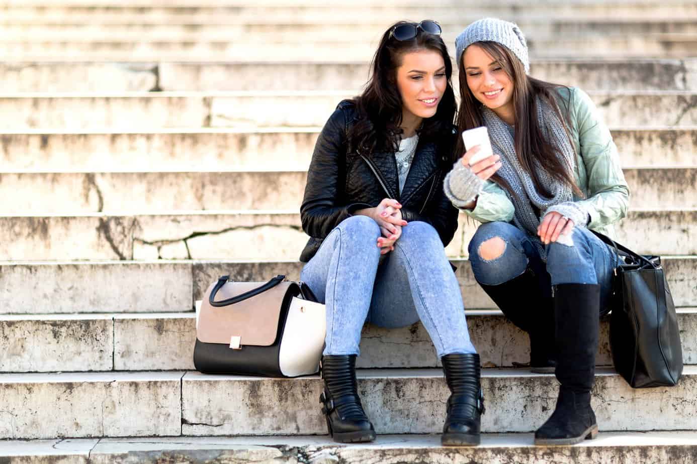 two women looking at a smartphone