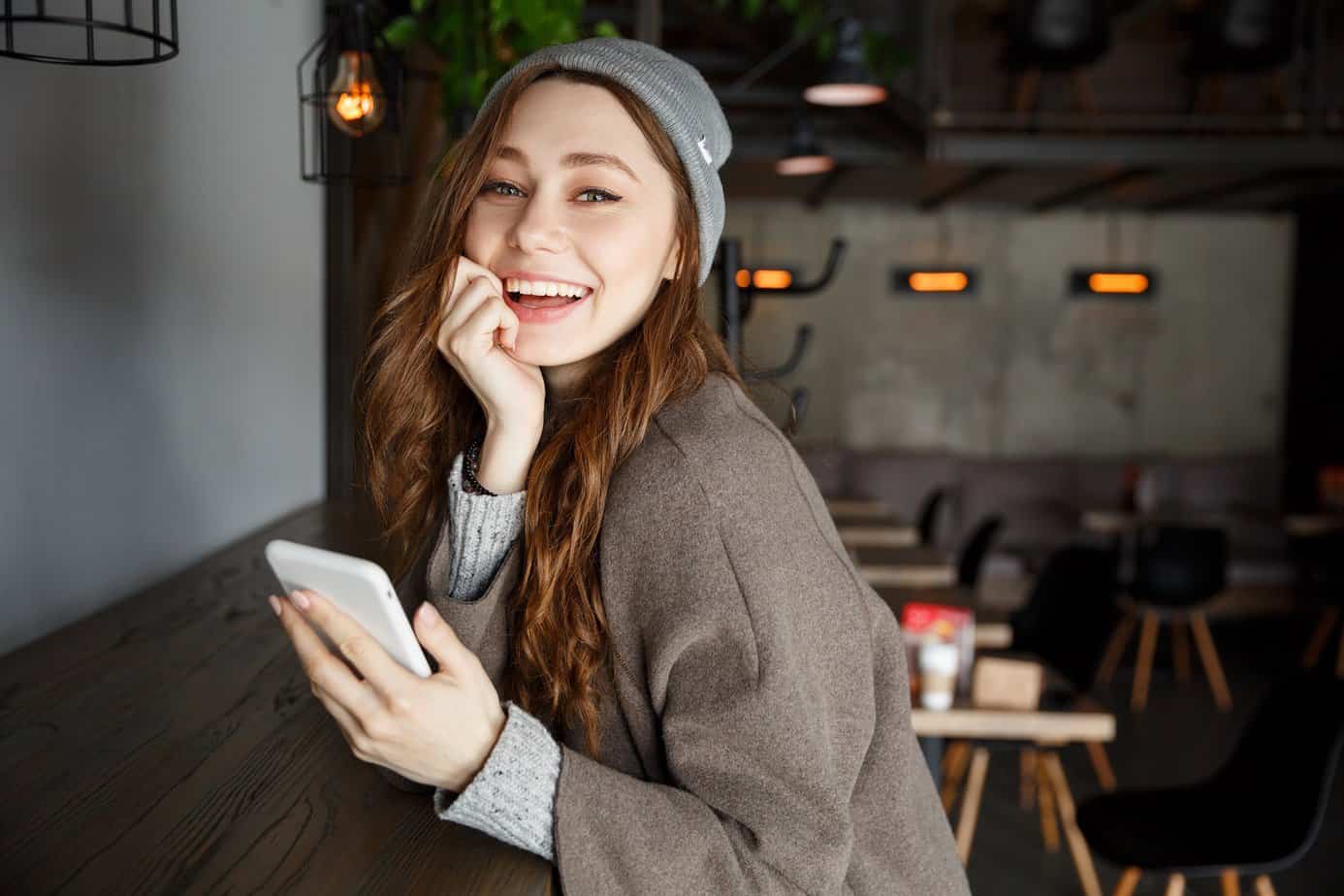 woman smiling with a smartphone in hand