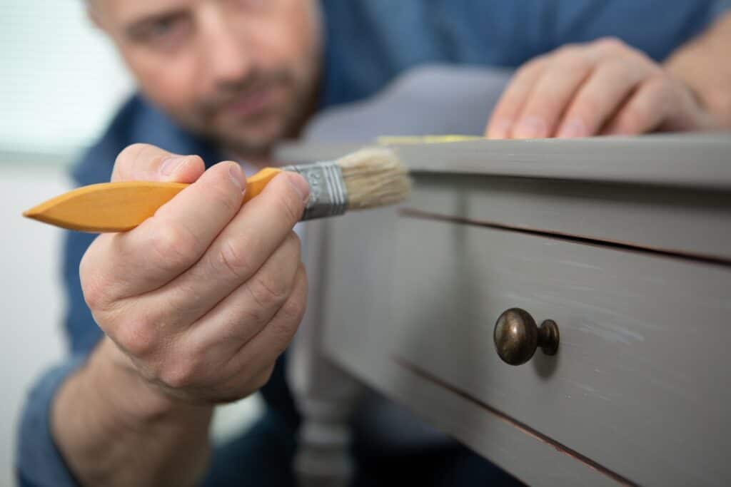 Man painting a small side table