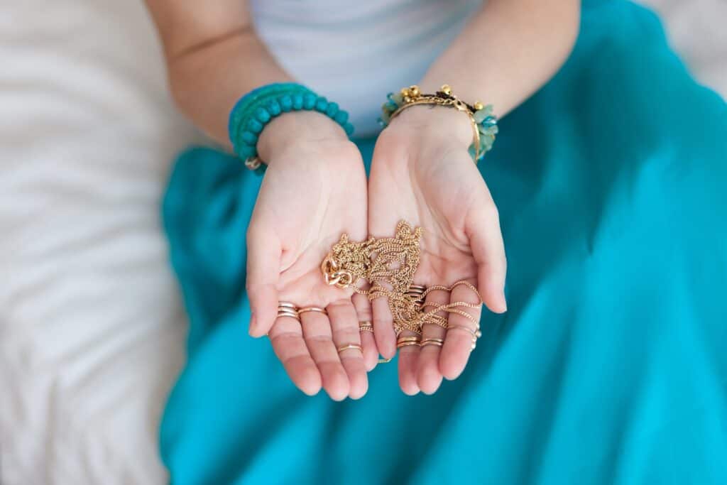 woman holding gold jewelry chains