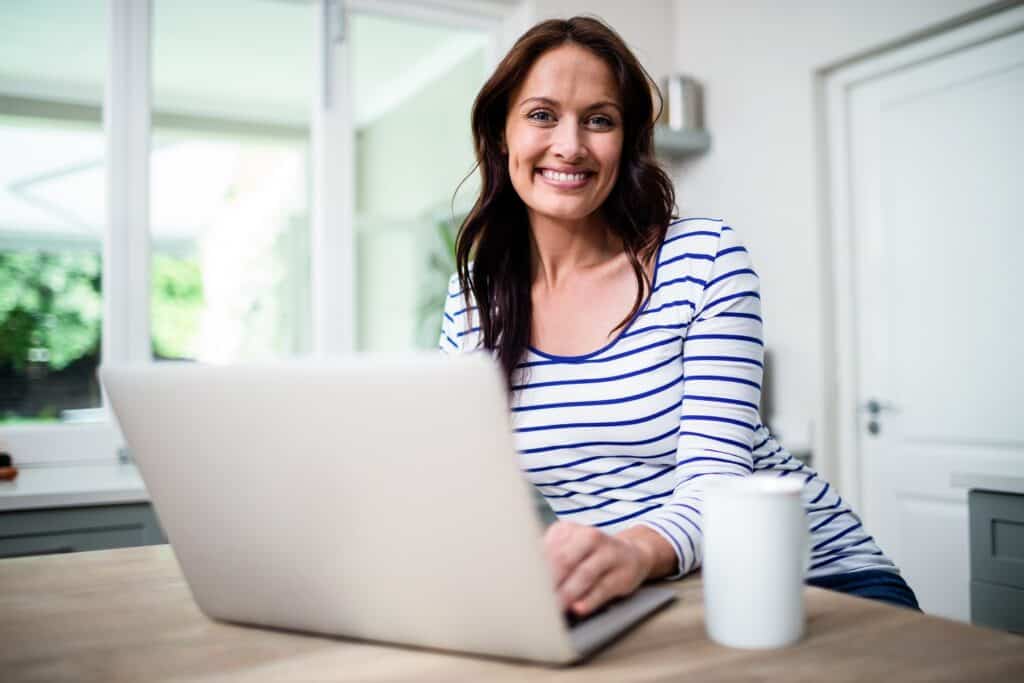 smart woman smiling in front of laptop