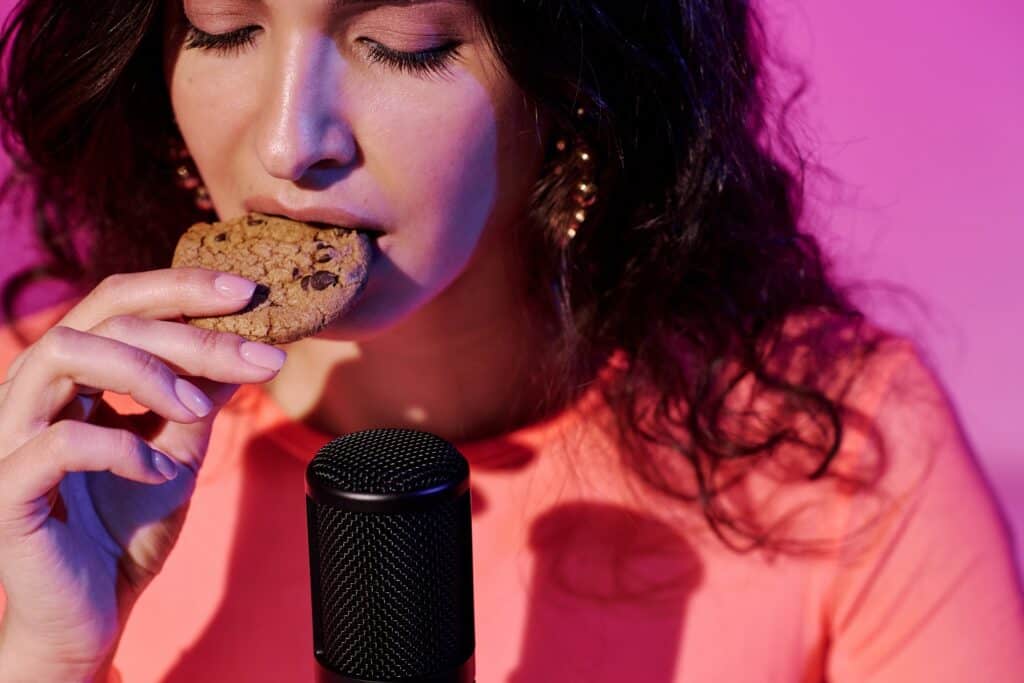 woman eating a cook in front of ASMR microphone